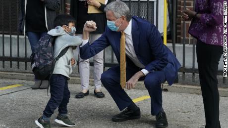 New York City Mayor Bill de Blasio pumps a welcome elbow with a pre-Q student at Queens.  The mayor insisted that schools provide in-person training.