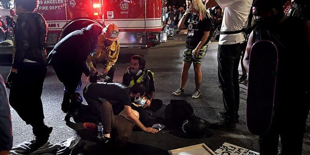 A protester who crashed into a car is seeking help from paramedics on September 24, 2020 in Hollywood, California.  (Getty Images)