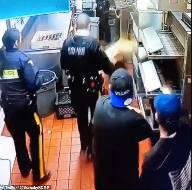 Officers with Burnaby Royal Canadian Mounted Police are seen upstairs in the restaurant's kitchen when a tine and tasher crashed through the ceiling tile