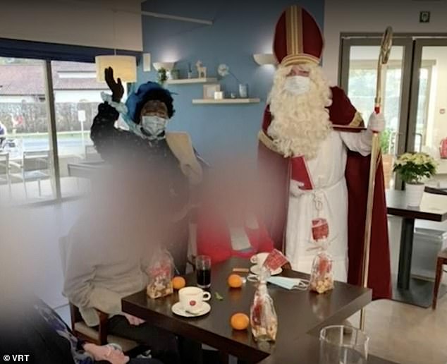 A Cinderella-clad volunteer greets (150: Santa and his Swarde Beat ('Black Beat') helpers as they visit the house to spread Christmas cheer among the 150 residents of the Hemelrijk Care Home in Antwerp, Mol.