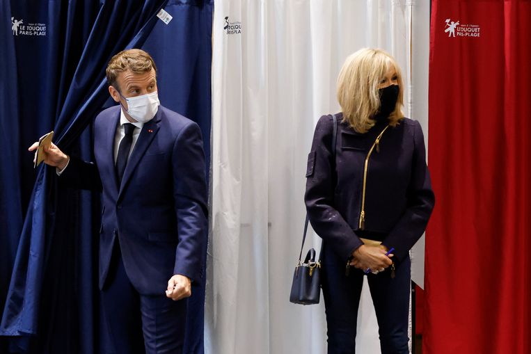 President Emmanuel Macron comes out of the voting booth between the curtains of the covid.  The elections were not a success for his party.  On the right his wife Brigitte.  Image REUTERS