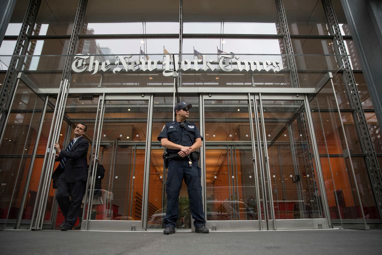 A police officer stands in front of the editors of the New York Times in New York.  Image AP