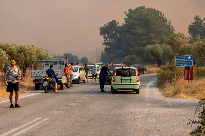 Tourists and locals watch a forest fire near Kalamonas on the Greek island of Rhodes.