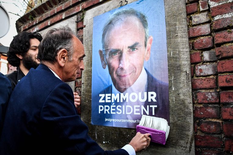 Eric Zemmour puts a campaign poster of himself on a wall in Honnecourt-sur-Escaut, northern France.  Statue of Bertrand Guay / AFP