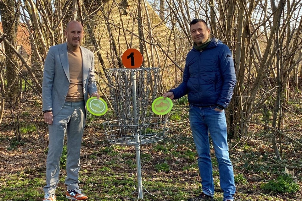 Mayor Peter Gysbrechts and Alderman of Sport Jeroen De Cuyper at one of the metal 'holes' of the disc golf course. 