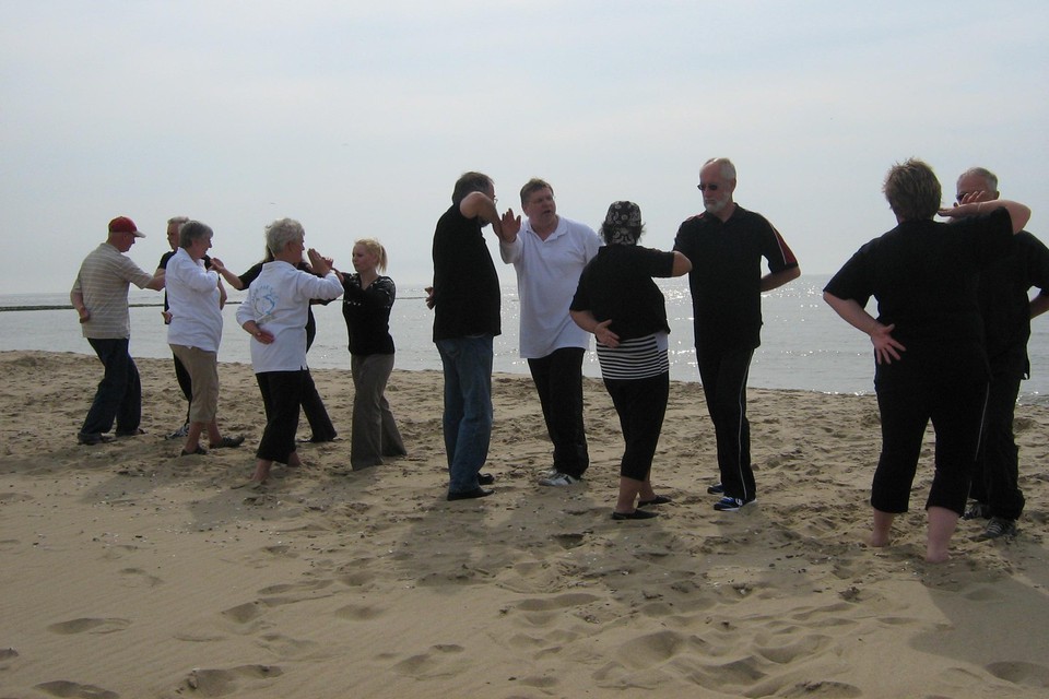Members of Jian Aan Zee practice tai chi on the beach.