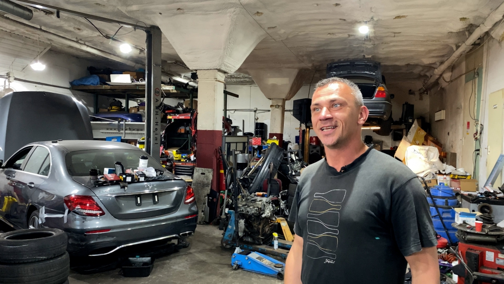 Garage owner Andrejs proudly shows his business after more than two weeks of forced closure