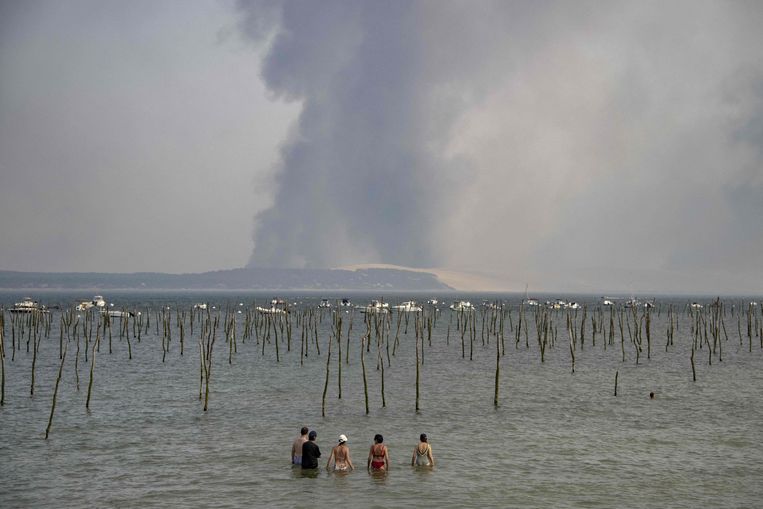 Bathers look out over a huge plume of smoke from a forest fire in La Teste, Gironde (southwestern France).  ImageAFP