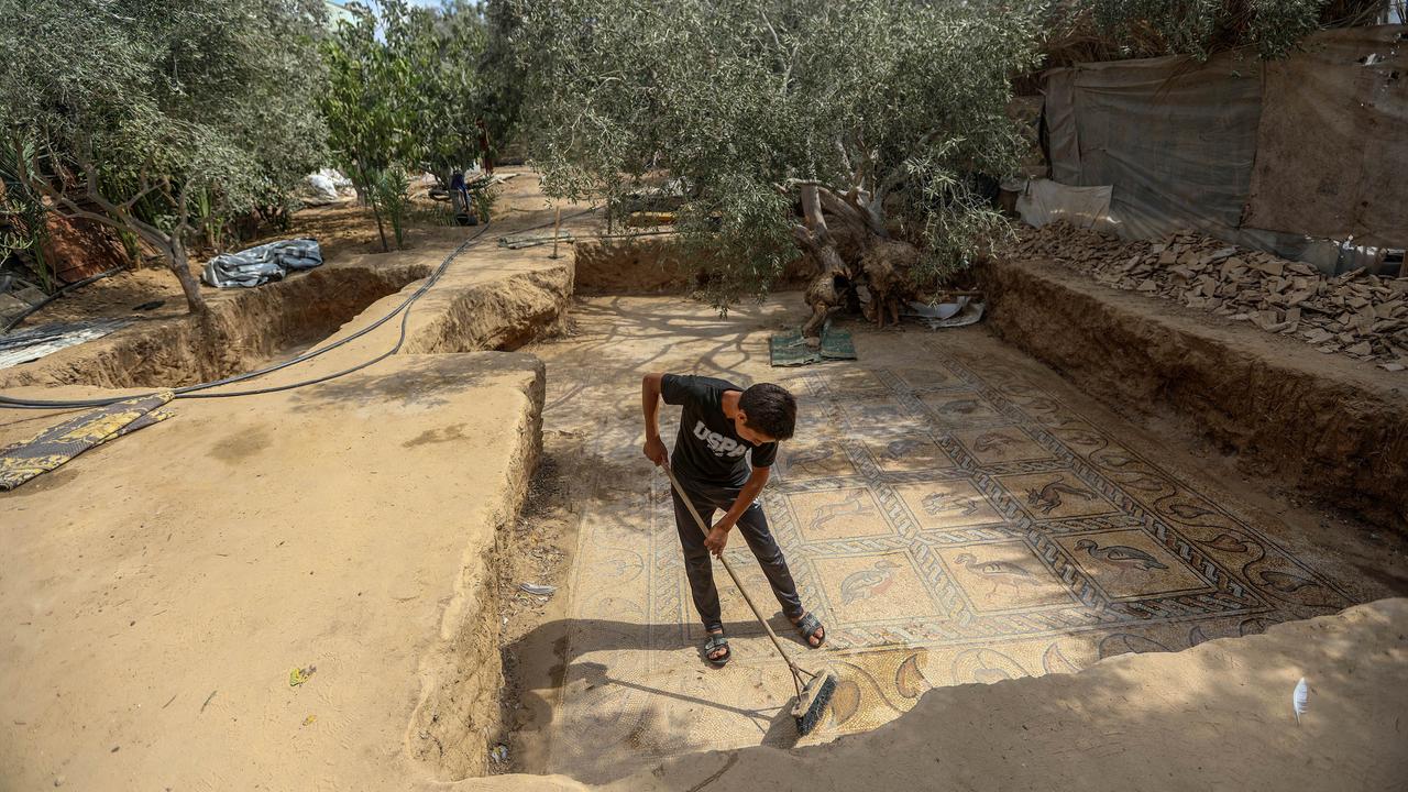 Farmer Salman Al Nabahin's son cleans the mosaic floor